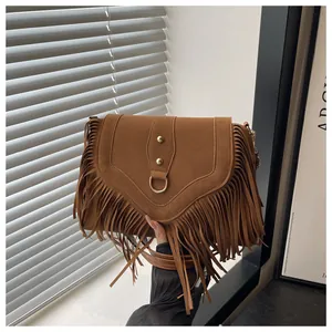 Nahaufnahme der camelfarbenen Wildledertasche mit Boho-Fransen und goldenen Nieten