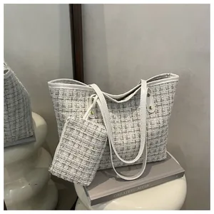 Détail macro du tweed blanc et de la poignée en cuir synthétique du cabas chic