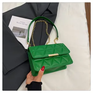 Detail of green quilted leather bag featuring gold chain strap and metal lock closure