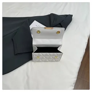Close-up of interior space and white quilted flap with golden magnetic buttons