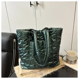 Macro shot of dark green quilted nylon tote with metallic finish and vertical stitching