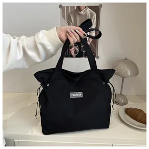 Detail of black drawstring tote bag with Fashion patch and large capacity for women