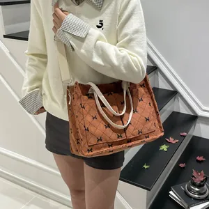 Caramel corduroy quilted tote bag with black bow print and adjustable crossbody strap