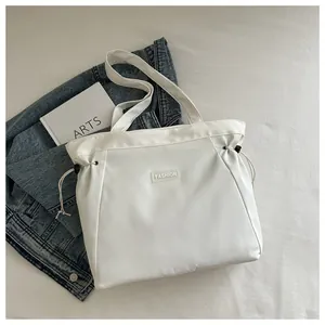 Detail view of white nylon tote bag with drawstring toggles and fashion label