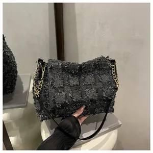 Close-up of fringe texture plaid shoulder bag with gold chain and leather strap