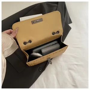 Close-up of beige leather bag interior showing spacious capacity and metallic lock detail