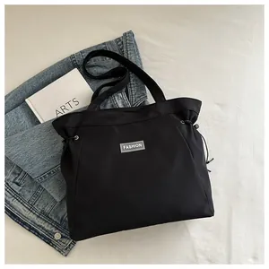 Detail of black tote bag with FASHION label, drawstring sides and large capacity