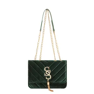 Dark green velvet crossbody bag with golden chain, chevron quilting and tassel detail