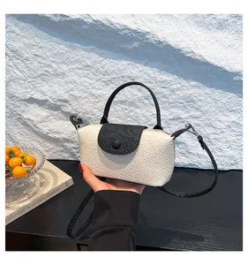 Macro view of textured white leather surface and black top handle on the stylish handbag