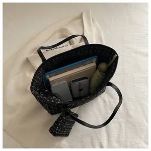 Intérieur spacieux d'un cabas en tweed avec tablette, parapluie et objets du quotidien