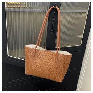 Detailed view of woven brown tote bag texture hanging on vintage cabinet handle
