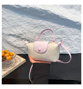 Detail of embossed floral pattern on pink and beige PU leather mini handbag