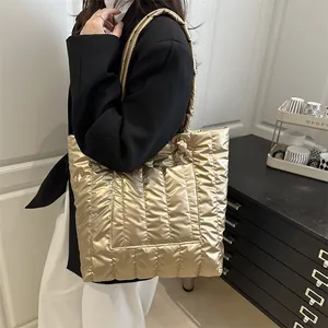 Metallic gold quilted tote bag for women, spacious shoulder bag shown with model