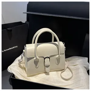 Detail of luxury cream white leather handbag inside an elegant black gift box packaging