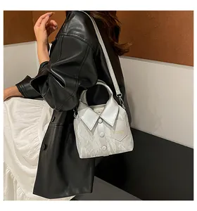 Detail of silver shirt-shaped bucket bag featuring collar and button accents