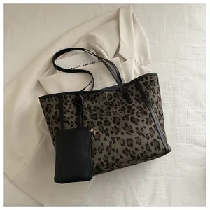 Top view of large leopard print tote bag with black leather straps and mini purse