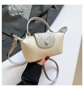 Close-up of contrast color mini square bag with embossed lace texture and handle