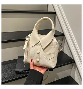 Detail of creative shirt-shaped cream bucket bag with button and collar design elements