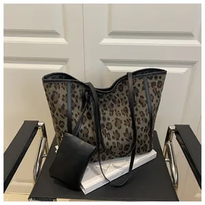 Detailed leopard print tote bag with black leather straps and matching small pouch