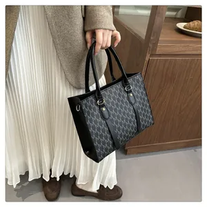 Classic tote bag featuring grey letter patterns with black handles and gold hardware accents