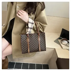 Detail of classic tote bag with monogram M pattern and leather handles on windbreaker model