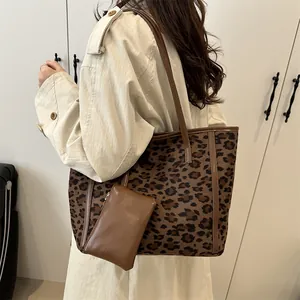 Large leopard print tote bag with small matching pouch shown on a shoulder