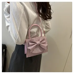 Détail du tissu à paillettes roses et du grand nœud décoratif sur ce sac de soirée élégant