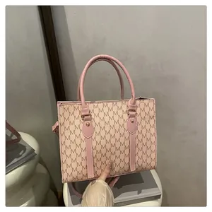 Detailed macro view of pink handbag featuring M-letter pattern and gold stud accents