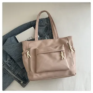 Detail of dusty pink tote bag with textured synthetic leather and functional side pockets
