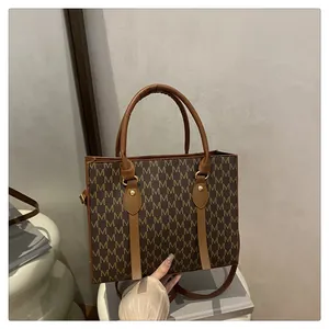 Detailed shot of brown monogram tote bag with gold rivets and leather handle