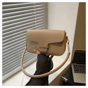 Detailed view of apricot leather shoulder bag with buckle strap and metal chain links