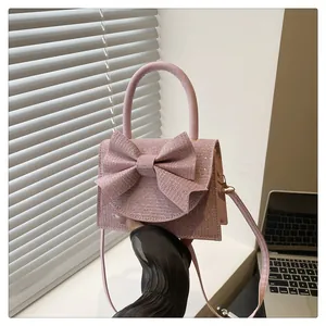 Détail du sac à main rose à paillettes avec grand nœud et bandoulière de style élégant