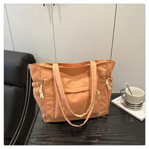 Detail view of the warm orange tote bag showing functional side pockets and nylon fabric