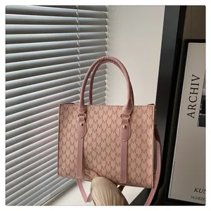 Detailed shot of pink monogram tote bag with gold hardware and removable strap