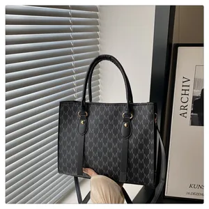 Detail of classic tote bag with M-letter monogram pattern and gold metal hardware
