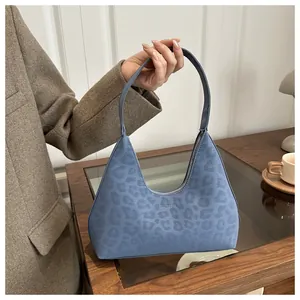 Detail der blauen Handtasche mit Leopardenmuster, Prägestruktur und Reißverschluss