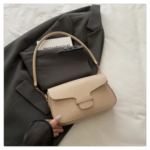 Detail of beige flap handbag with matte leather texture and elegant gold chain link handles