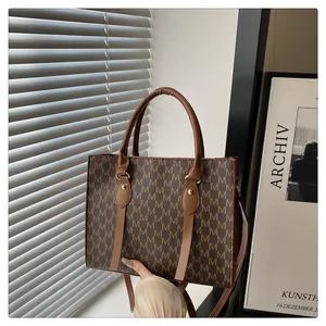 Close-up of classic monogram tote bag with brown leather handles and chic metal hardware