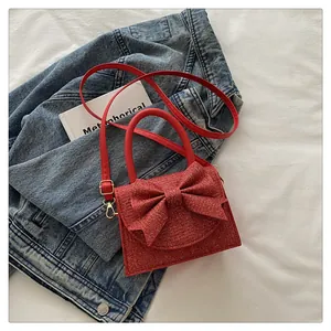 Vue de dessus d'un sac à main rouge scintillant avec nœud et paillettes sur denim