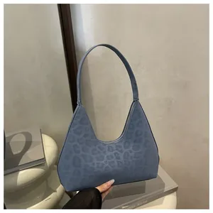 Detail der blauen Schultertasche mit Leopardenmuster-Prägung und mattem Leder-Finish