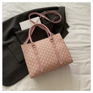 Detailed close-up of pink tote bag featuring M-letter monogram and detachable shoulder strap