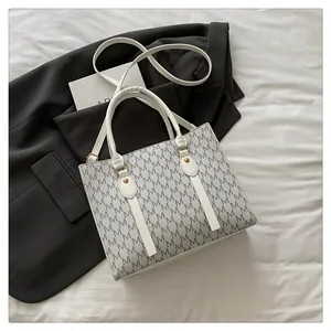 Detailed shot of white tote bag with M-letter print on black blazer and white cloth