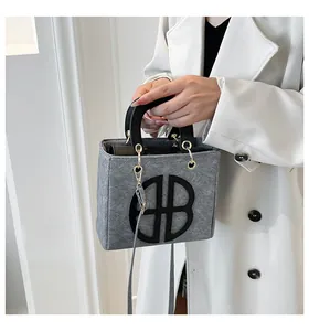 Détail du sac à main en feutre gris avec design BB noir et finitions dorées