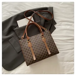 Detailed macro view of monogram M texture and leather trim on a brown crossbody bag