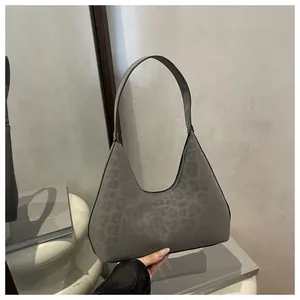 Details der grauen Wildleder-Handtasche mit Leopardenmuster und Logoprägung
