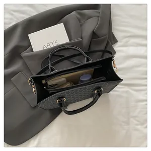 Top view of the black monogram tote bag showing interior storage and gold hardware