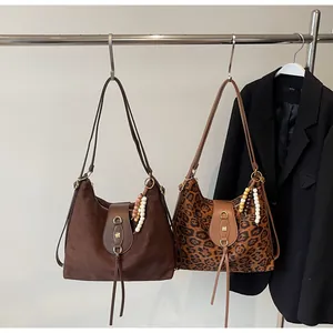 Détail de sacs fourre-tout en daim avec imprimé léopard et boucle en métal vintage