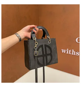 Détail d'un sac à main en cuir noir mat avec motif B découpé et accents dorés