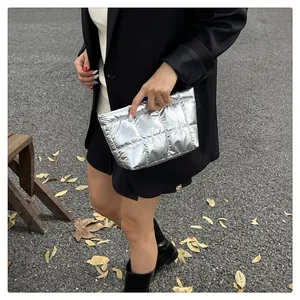 Détail de la texture en tissu matelassé argenté sur une pochette à finition métallique