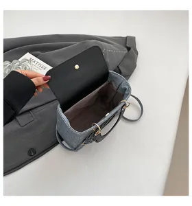 Détail de l'intérieur du sac en jean bleu avec finitions en cuir noir et fermoir